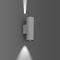 Silberne Wandlampe mit zylindrischem Design strahlt Licht nach oben und unten, platziert auf grauer Wand, modernes Ambiente.