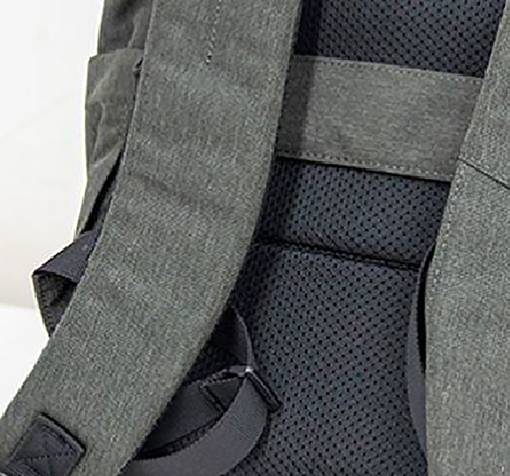 Ein grauer Rucksack mit gepolsterten Trägern liegt auf einer Oberfläche. Die Struktur der Rückseite ist sichtbar, zeigt Netzmaterial.