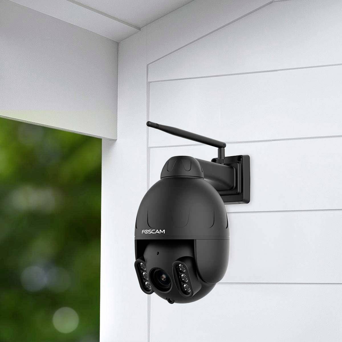 Eine Überwachungskamera ist an einer weißen Wand montiert. Sie zeigt nach außen und verfügt über eine Antenne für drahtlose Kommunikation.