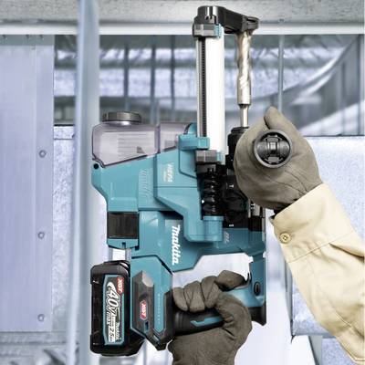 Eine Person hält eine blaue akkubetriebene Bohrmaschine und bohrt in ein Metallrohr. Die Maschine hat eine schwarze Batterie und besitzt eine hohe Spannung.