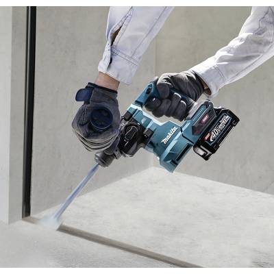 Person benutzt kabellosen Bohrhammer, um Beton zu bearbeiten. Der Bohrhammer ist blau und hat einen Akku.
