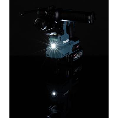 Ein blauer, kabelloser Bohrhammer mit einem leuchtenden LED-Licht in einem dunklen Raum, auf einer reflektierenden Oberfläche.
