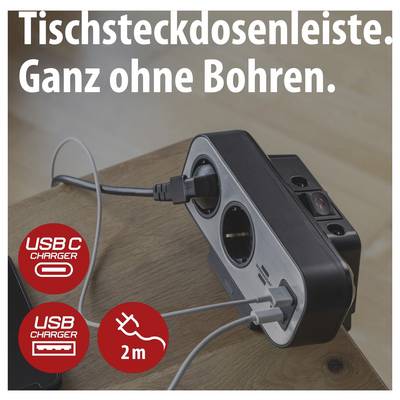Werbebild einer Tischsteckdosenleiste mit zwei USB-Anschlüssen, 'Ganz ohne Bohren', auf einem Holztisch mit eingesteckten Kabeln; Icons zeigen USB-C, USB und 2 m.<br>