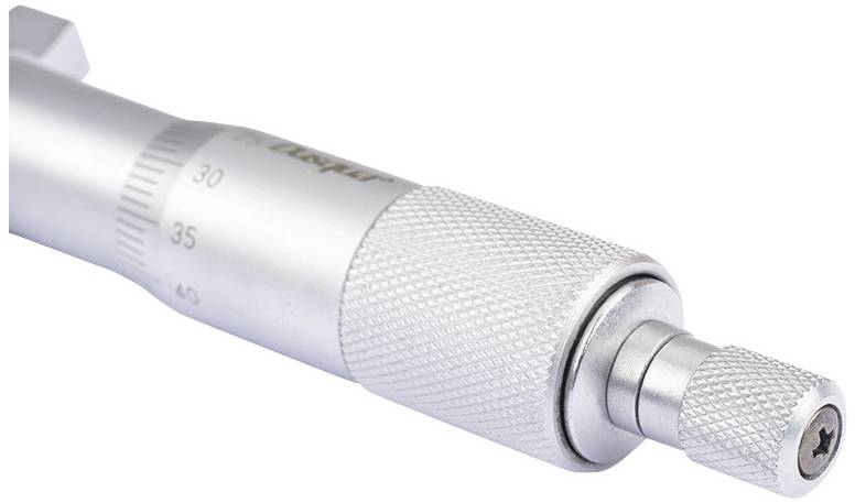 Ein silbernes Präzisionsmikrometer mit Skala, das zur Messung kleiner Abstände und Objekte verwendet wird, ist vergrößert dargestellt.