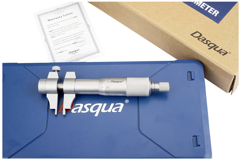 Das Bild zeigt ein Mikrometer mit blauer Aufbewahrungsbox und Garantieschein, neben einem Karton mit 'Dasqua'-Aufschrift.