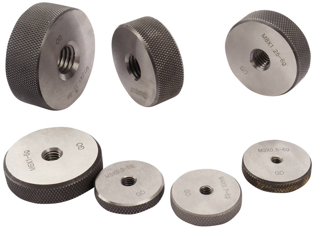 Mehrere metallene Prüfstopfen mit Gewinde, in unterschiedlichen Größen, zur Überprüfung von Innengewinden.