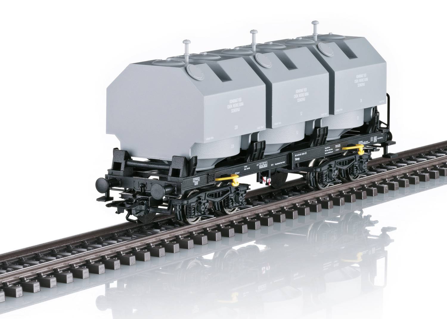 Ein Modell eines grauen Eisenbahn-Güterwagens mit drei Silotanks auf Schienen, detailliert gestaltet für eine Sammlerausstellung.