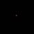 Ein kleines, rotes Licht leuchtet in der Mitte eines schwarzen Hintergrunds.