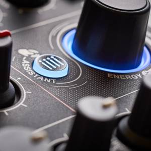 Nahaufnahme eines schwarzen Bedienfelds mit beleuchteten blauen Knöpfen und den Aufschriften 'ASSISTANT' und 'ENERGY'.