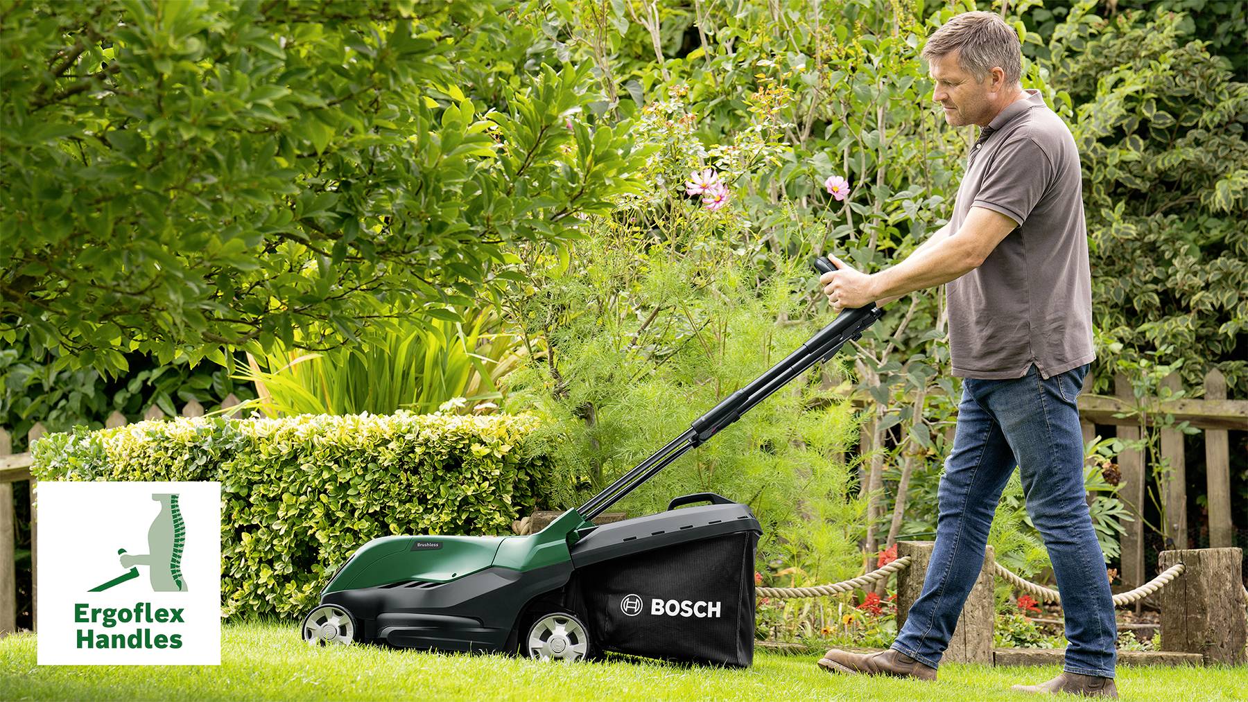 Ein Mann mäht Rasen mit einem Bosch-Rasenmäher. Er nutzt ergonomische 'Ergoflex Handles'. Der Garten ist grün und gepflegt.
