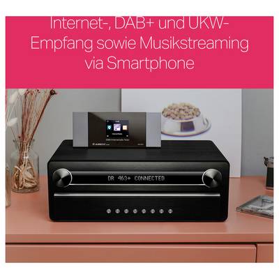 Ein schwarzes Digitalradio steht auf einem Tisch. Oben zeigt ein Display 'DR 463+ CONNECTED'. Im Hintergrund ein Teller mit Gebäck.