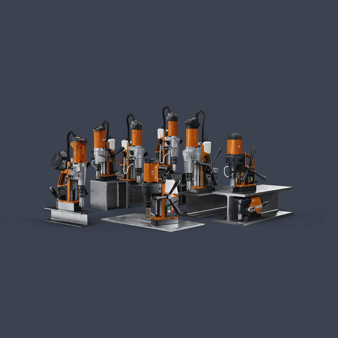 Eine Reihe von sechs orangefarbenen Magnetbohrmaschinen auf dunklem Hintergrund, aus verschiedenen Winkeln präsentiert.