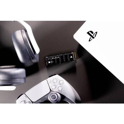 Schwarze Festplatte, weißer Controller und Kopfhörer neben einer Spielekonsole. Thema: Gaming-Zubehör und Technik.