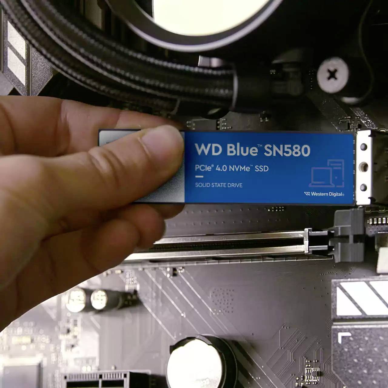 Eine Hand installiert eine 'WD Blue SN580' SSD in einen Computer.