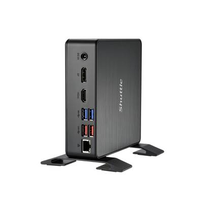 Schwarzer Mini-PC von Shuttle mit mehreren Anschlüssen auf der Vorderseite, einschließlich USB- und HDMI-Ports, stehend auf einem Tisch.