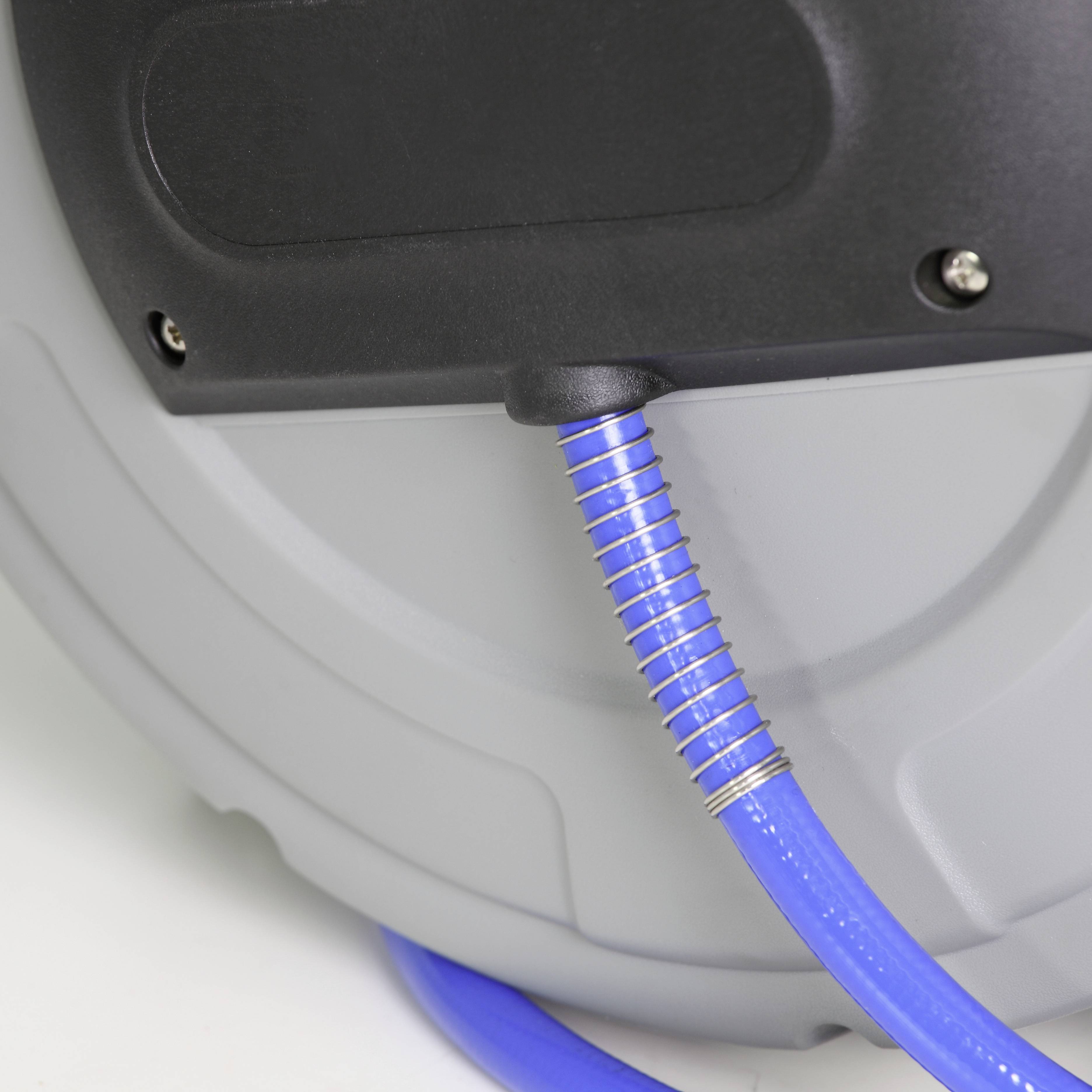 Eine Nahaufnahme einer grauen Kabelaufwicklung mit einem blauen Schutzrohr, das das Kabel führt. Hintergrund unscharf.