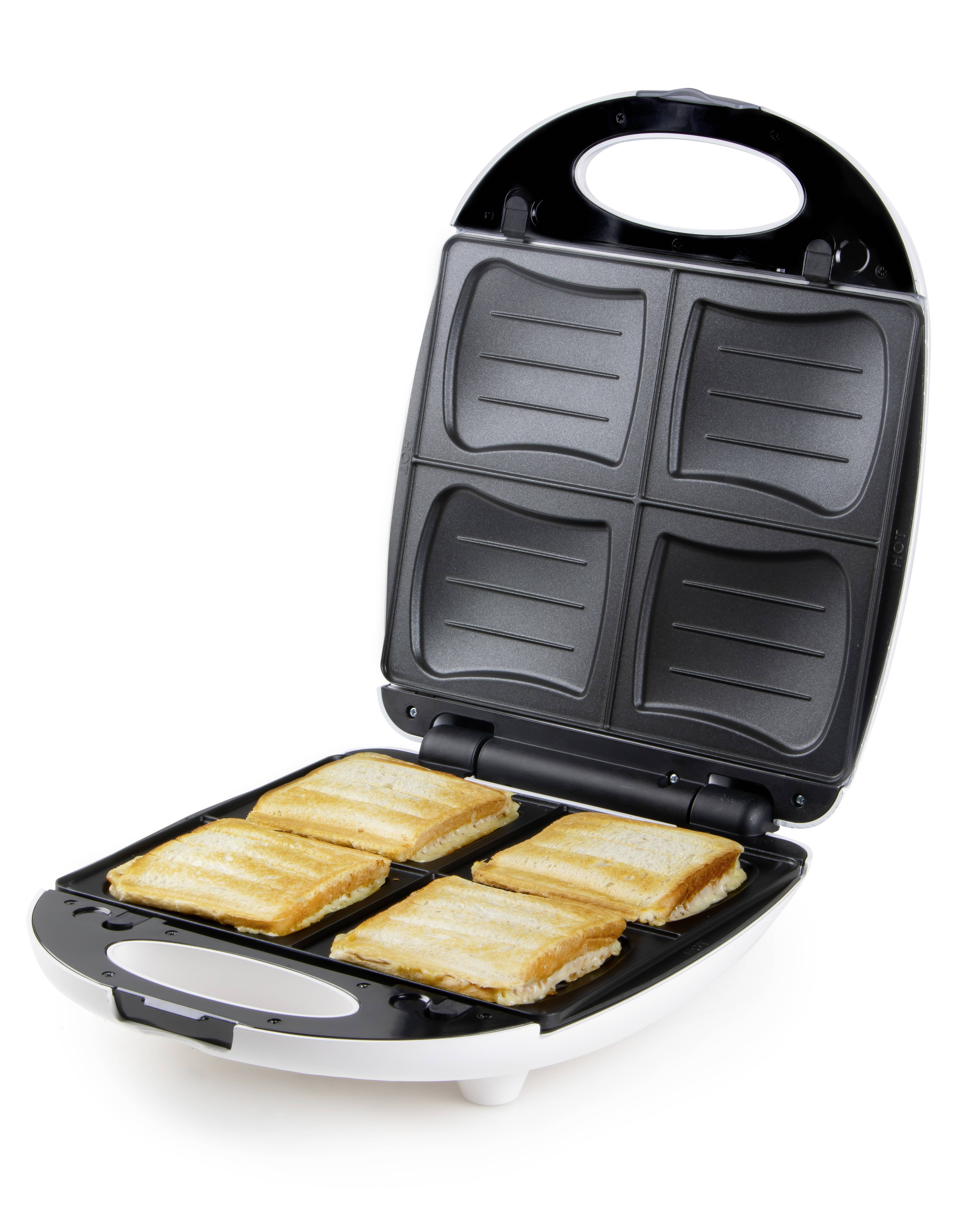 Ein geöffneter Sandwichmaker mit vier gebräunten Sandwiches im Inneren. Schwarze Platten mit Rillen für gleichmäßiges Toasten.