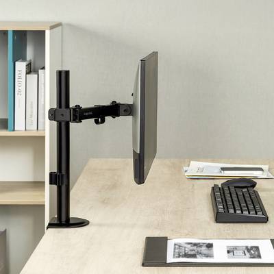 Ein Computerbildschirm auf einem verstellbaren Arm steht auf einem Schreibtisch neben einer Tastatur. Im Hintergrund ist ein Bücherregal.