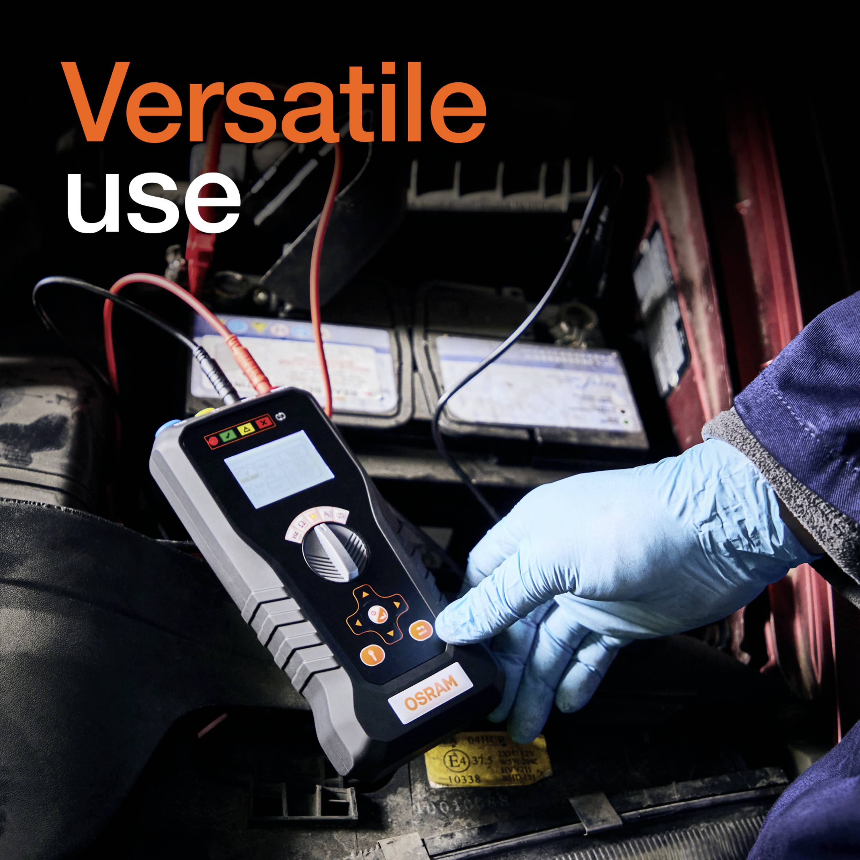 Ein Mechaniker mit blauen Handschuhen verwendet ein Diagnosegerät an einer Autobatterie. Text: 'Versatile use'.