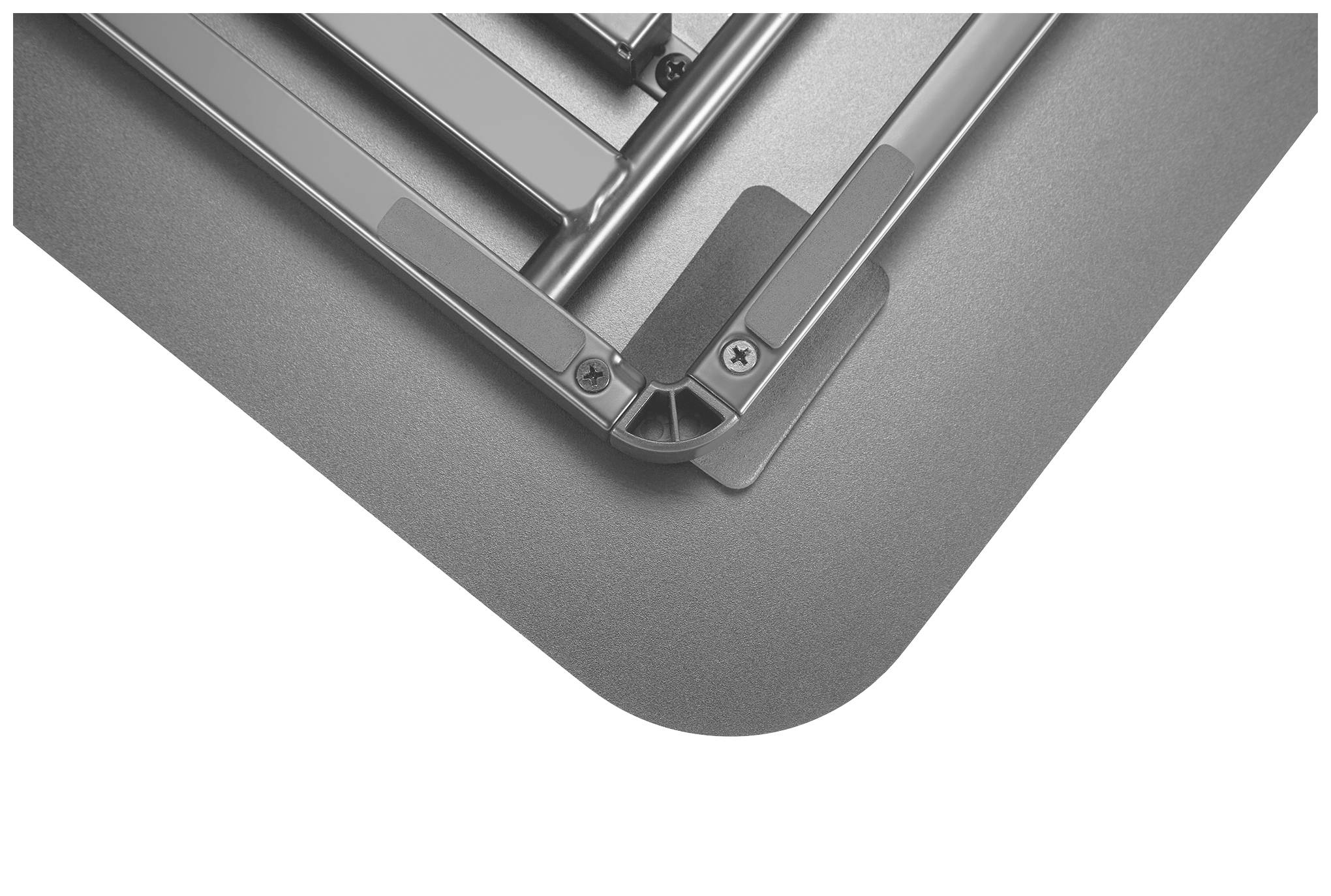 Ecke eines grauen technischen Geräts mit abgerundeten Kanten und Schrauben zu sehen.