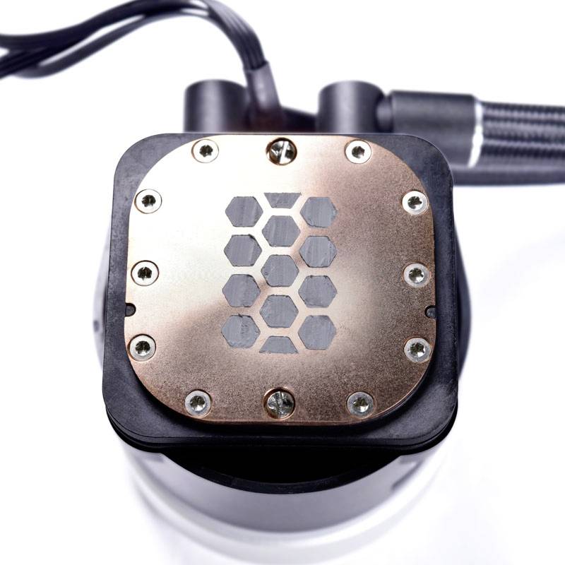 Kühlkörper einer CPU-Wasserkühlung mit sechseckigem Muster auf Kupferplatte, Schrauben an den Ecken, graue Kabel im Hintergrund.