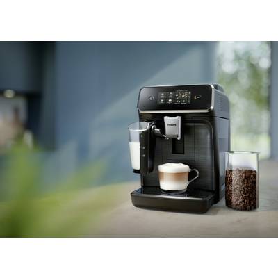Eine Kaffeemaschine bereitet einen Cappuccino zu. Neben der Maschine stehen ein Glas mit Milch und ein Behälter mit Kaffeebohnen.