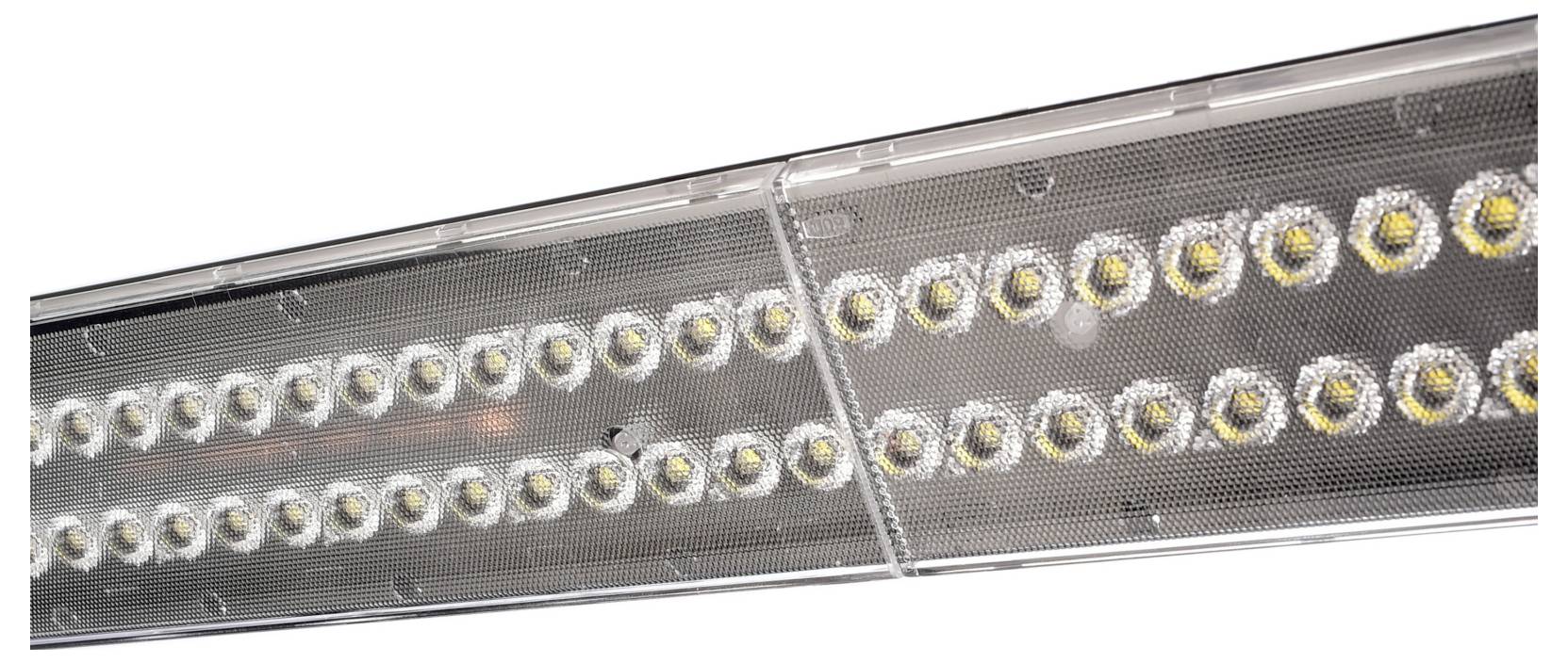 Nahaufnahme einer langen, rechteckigen LED-Leuchte mit zwei Reihen runder Leuchtmittel hinter einer perforierten Metallabdeckung.