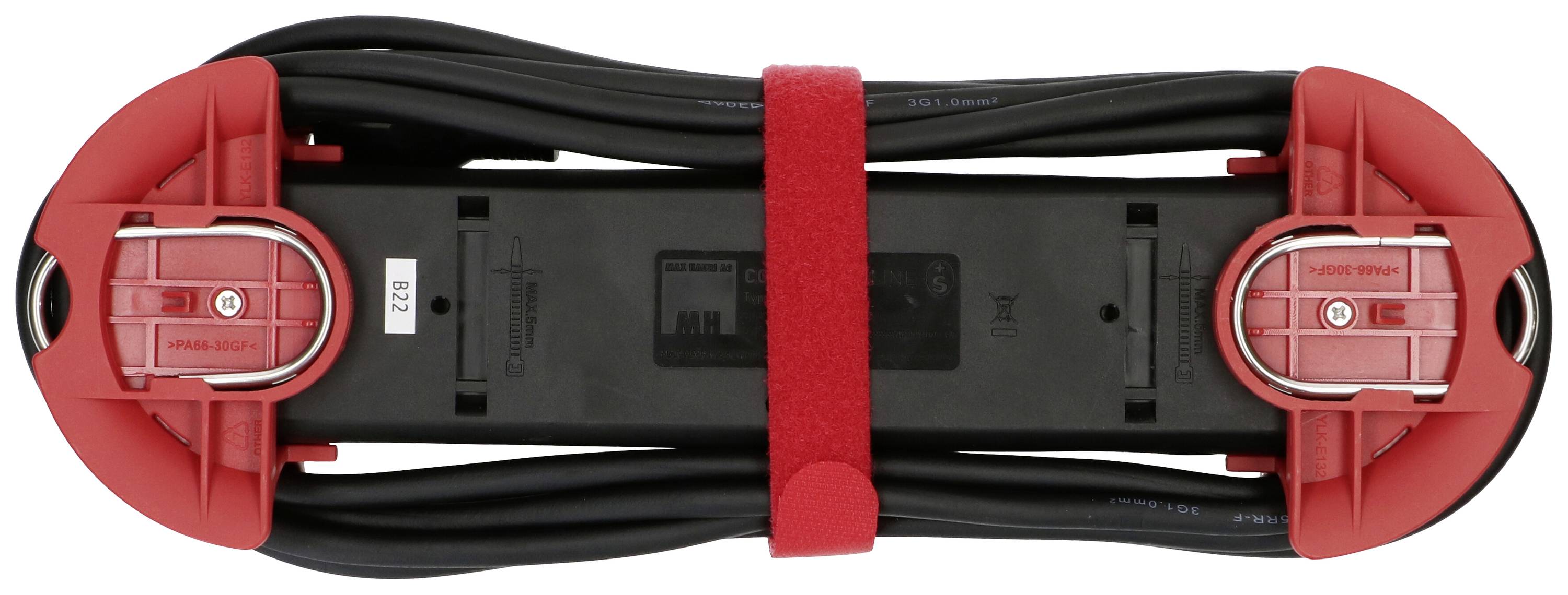 Ein schwarzes Gerät mit rotem Rand und Kabeln, vermutlich ein Elektrowerkzeug oder Batteriezubehör. Es ist mit einem roten Band gesichert.