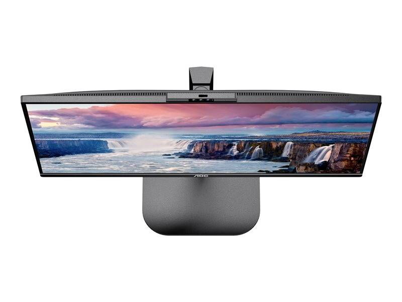 Monitor auf Schreibtisch mit Bild von Landschaft. Hauptmotiv sind schroffe Klippen und ein fließendes Gewässer unter rosa Himmel.