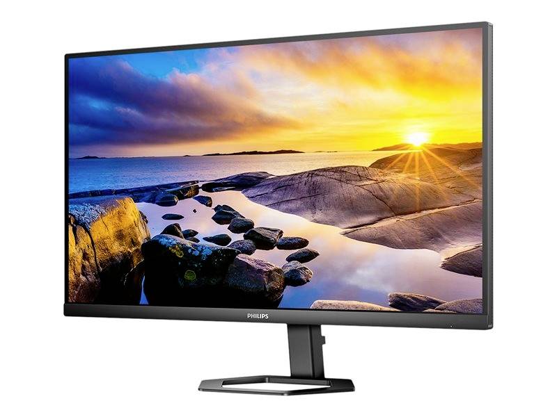 Ein Monitor zeigt ein lebhaftes Naturbild mit Sonnenuntergang über felsiger Küstenlandschaft.