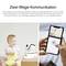 Baby mit Stofftier neben Überwachungskamera. Smartphone zeigt Kamerabild und Steuerelemente. Thema: Überwachung und Kommunikation.