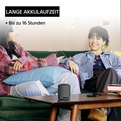 Zwei lachende Personen sitzen auf einem Sofa. Text: 'Lange Akkulaufzeit, bis zu 16 Stunden'.