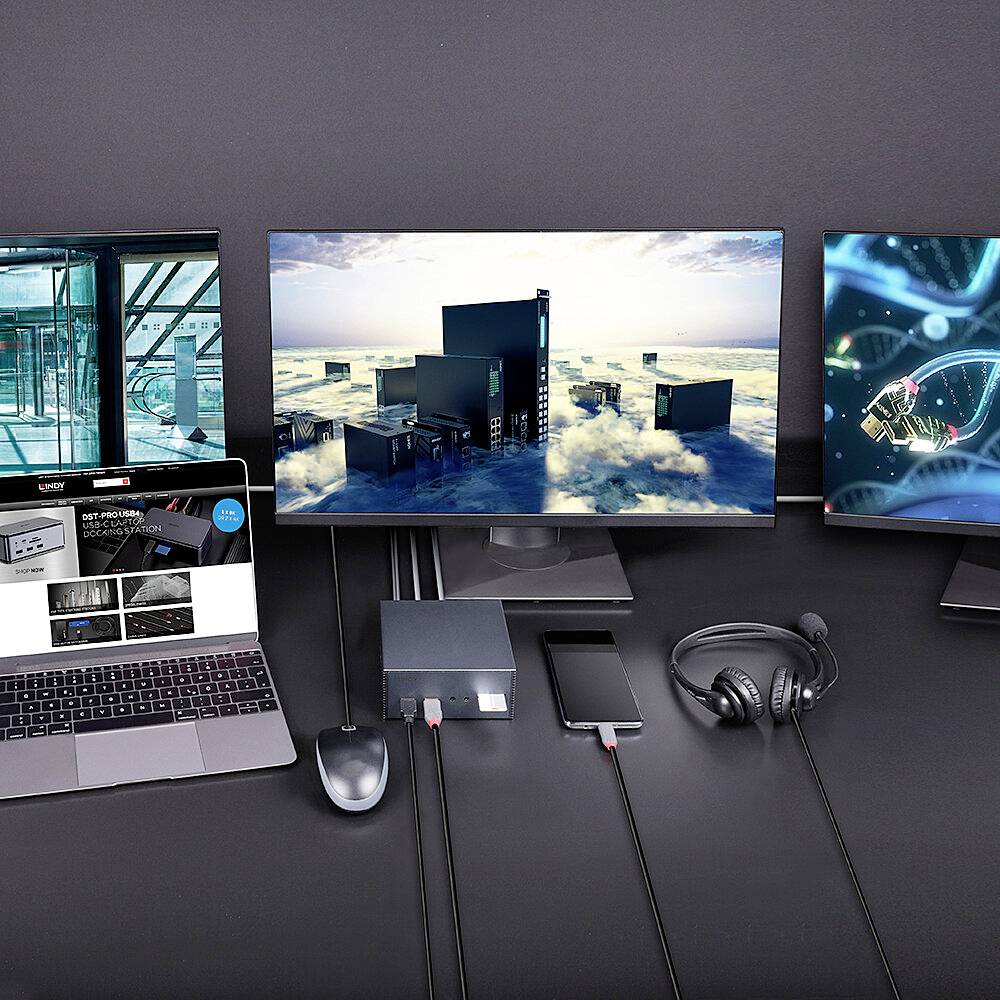 Zwei Monitore, ein Laptop, Smartphone, Maus, Kopfhörer und Kabel auf einem Schreibtisch. Laptopschirm zeigt eine Website.