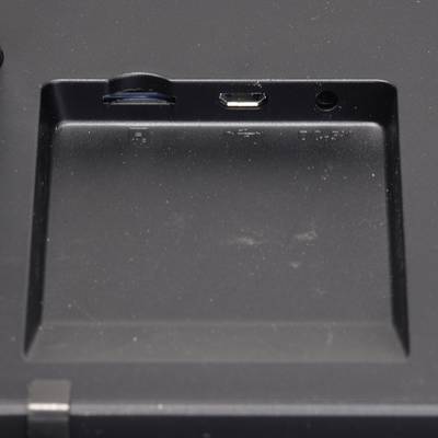 Ein leerer Steckplatz mit Micro-USB-Anschluss und Audiobuchse auf einem schwarzen Gerät. Verwendet für externe Verbindungen.