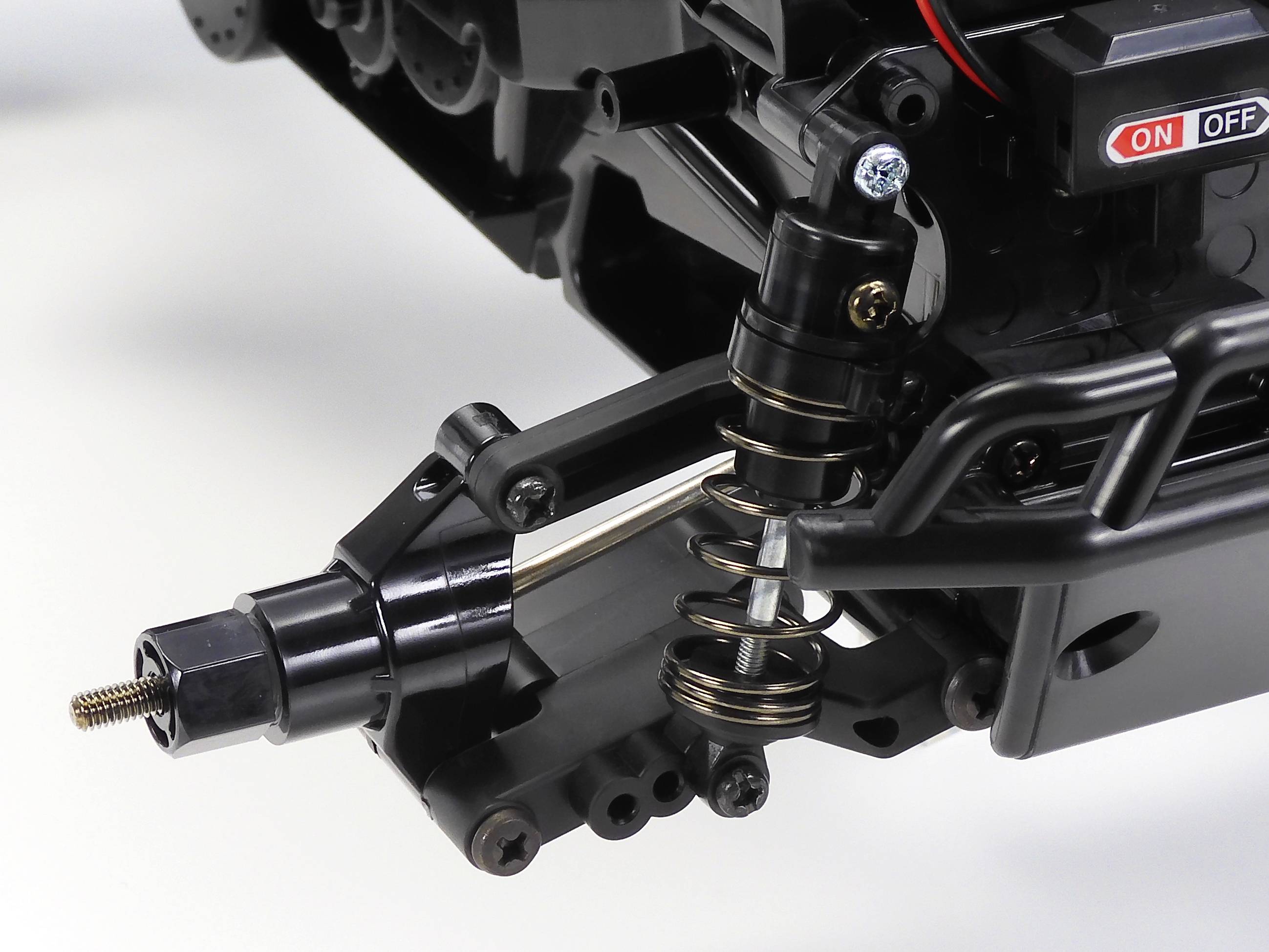 Nahaufnahme eines RC-Auto-Stoßdämpfers, der einen Metallfedermechanismus und eine Schraubbefestigung zeigt.