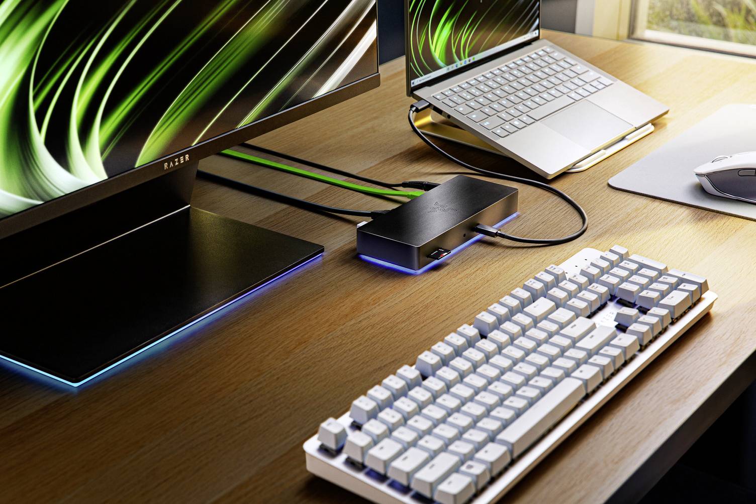 Schreibtisch mit Tastatur, Monitor und Laptop, verbunden über eine Dockingstation. Stromlinienförmiger Arbeitsplatz für effizientes Arbeiten.