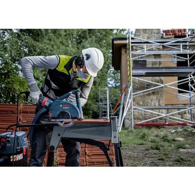 Ein Bauarbeiter trägt Schutzkleidung und verwendet eine Handsäge, um ein Metallrohr zu schneiden. Im Hintergrund ist ein Gerüst zu sehen.
