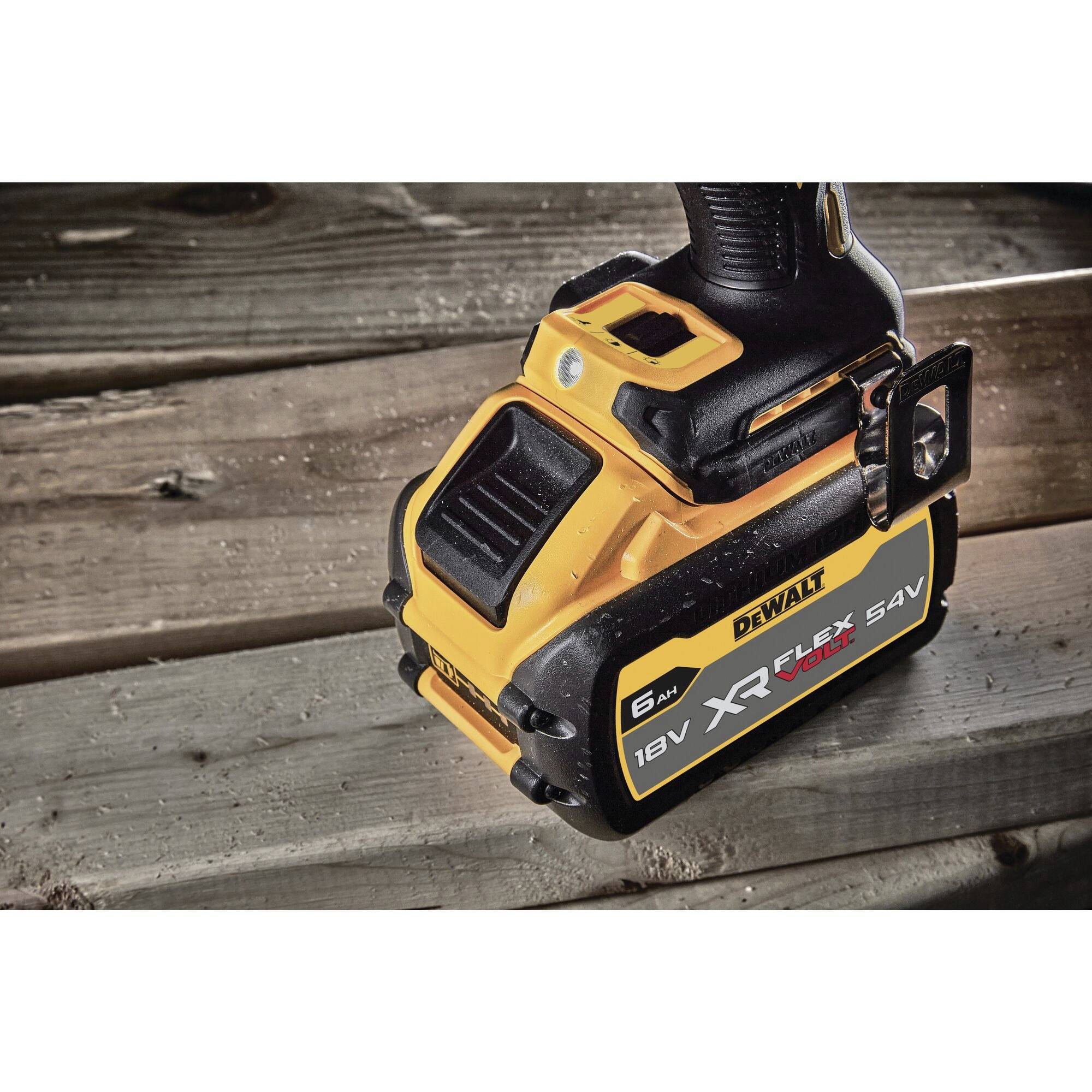 Ein Dewalt-Akkupack liegt auf Holzbrettern. Das Akku ist schwarz und gelb, mit der Aufschrift 'XR FlexVolt 18V 54V'.