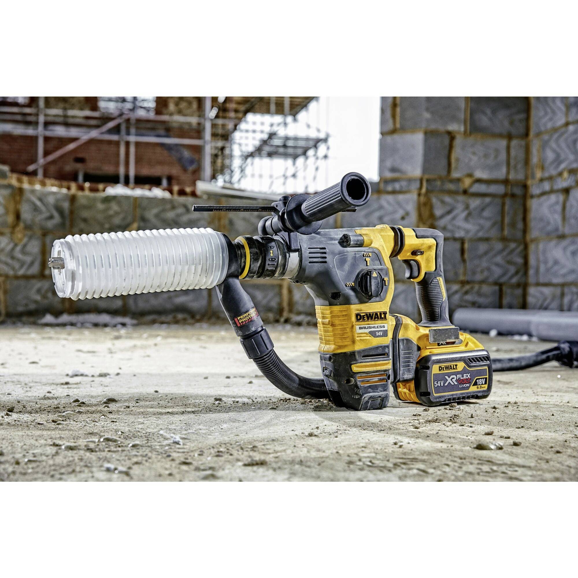 'DEWALT-Bohrhammer auf Baustelle', abgebildet auf sandigem Boden mit unfertigen Mauerwerkswänden im Hintergrund.