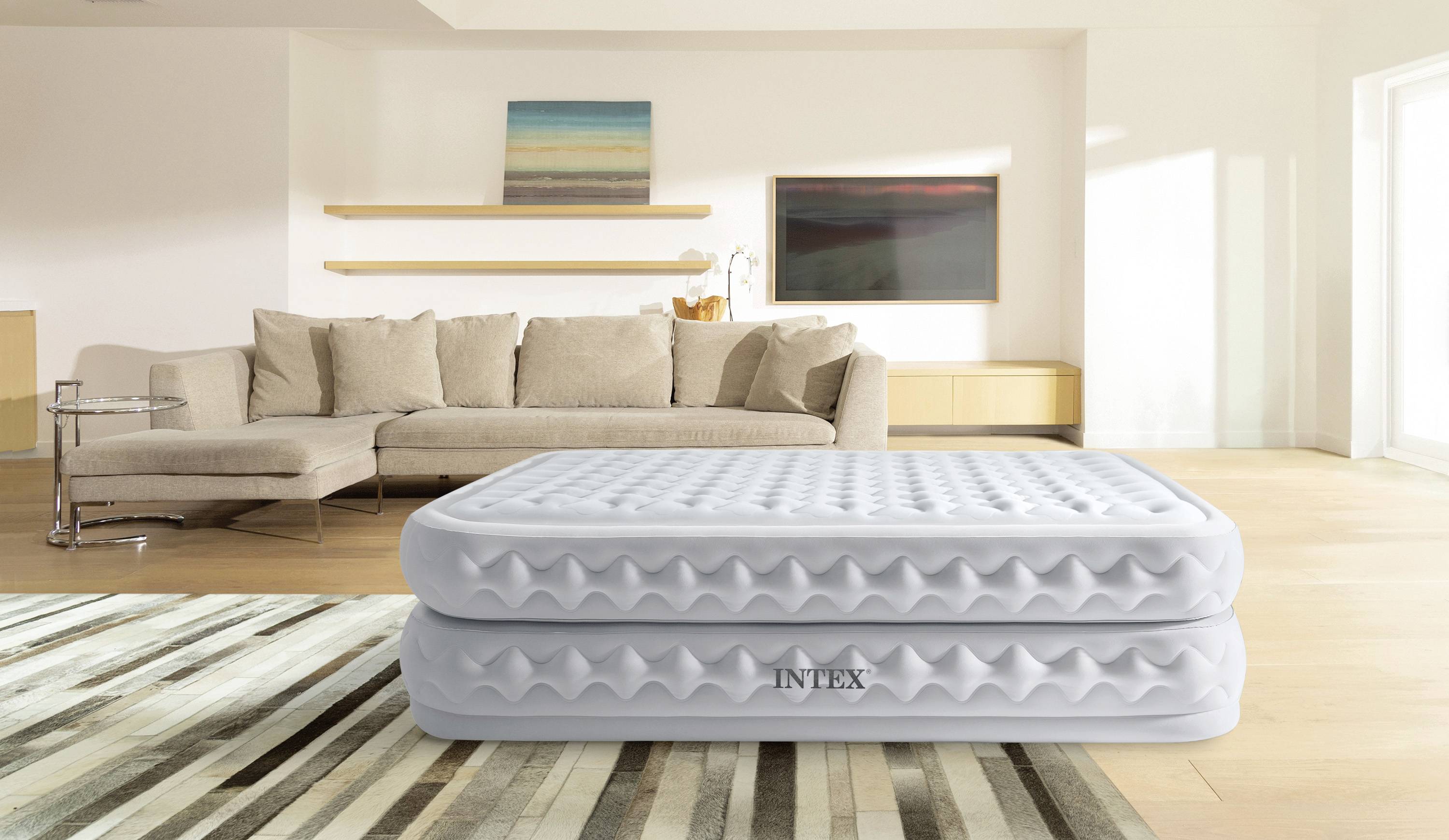 Aufblasbares Bett in einem modernen Wohnzimmer mit beige Sofa und minimalistischem Dekor.
