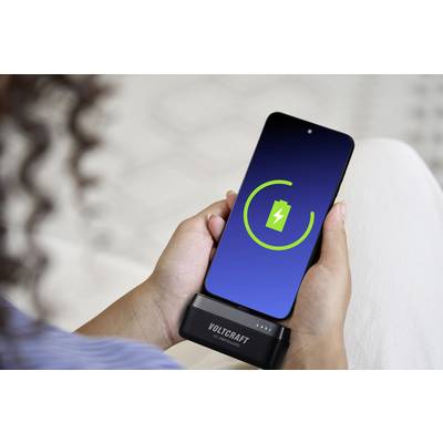 Person hält Smartphone mit Ladeanzeige auf dem Bildschirm. Gerät wird mit einem VOLTCRAFT-Ladegerät aufgeladen.