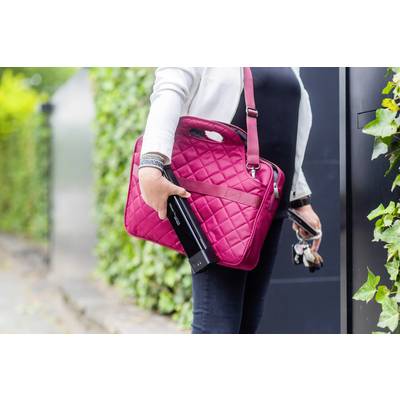 Eine Person hält eine pinke Tasche und einen endgültigen Thermobecher in der Hand. Im Hintergrund sind Büsche sichtbar.