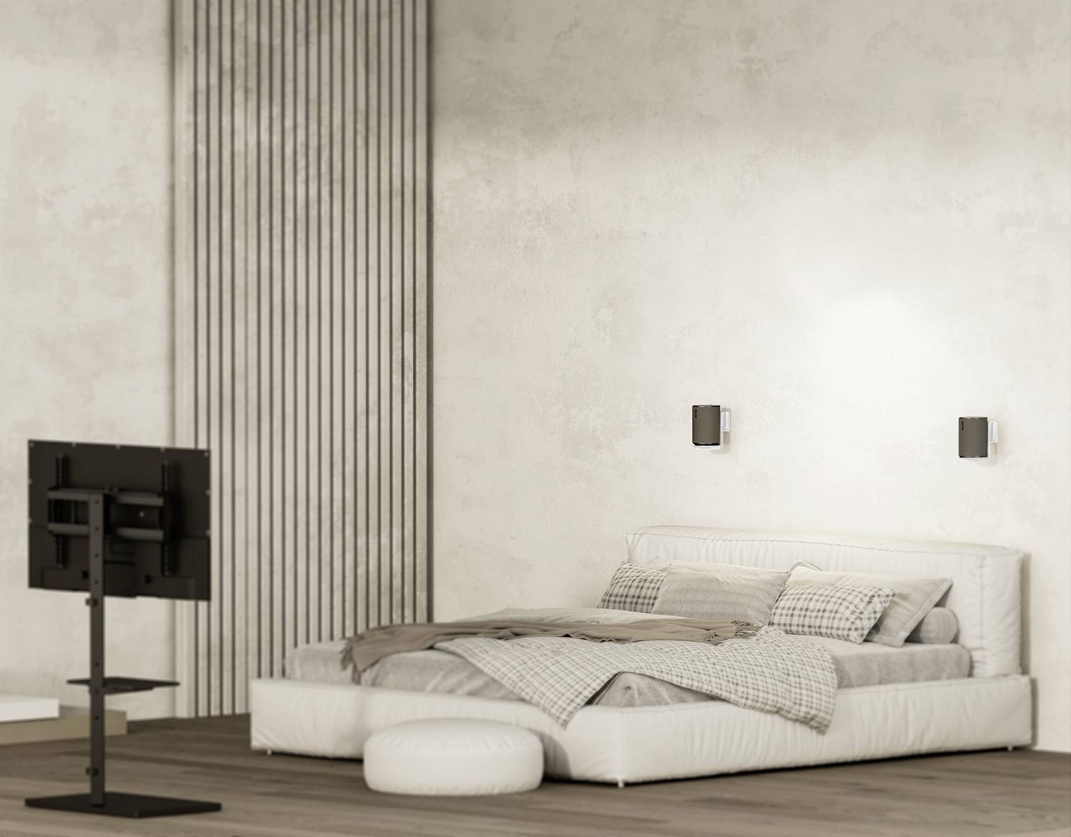 Ein helles Schlafzimmer mit einem niedrigem Bett auf Holzfußboden. Ein Fernseher steht auf einem Ständer gegenüber dem Bett.