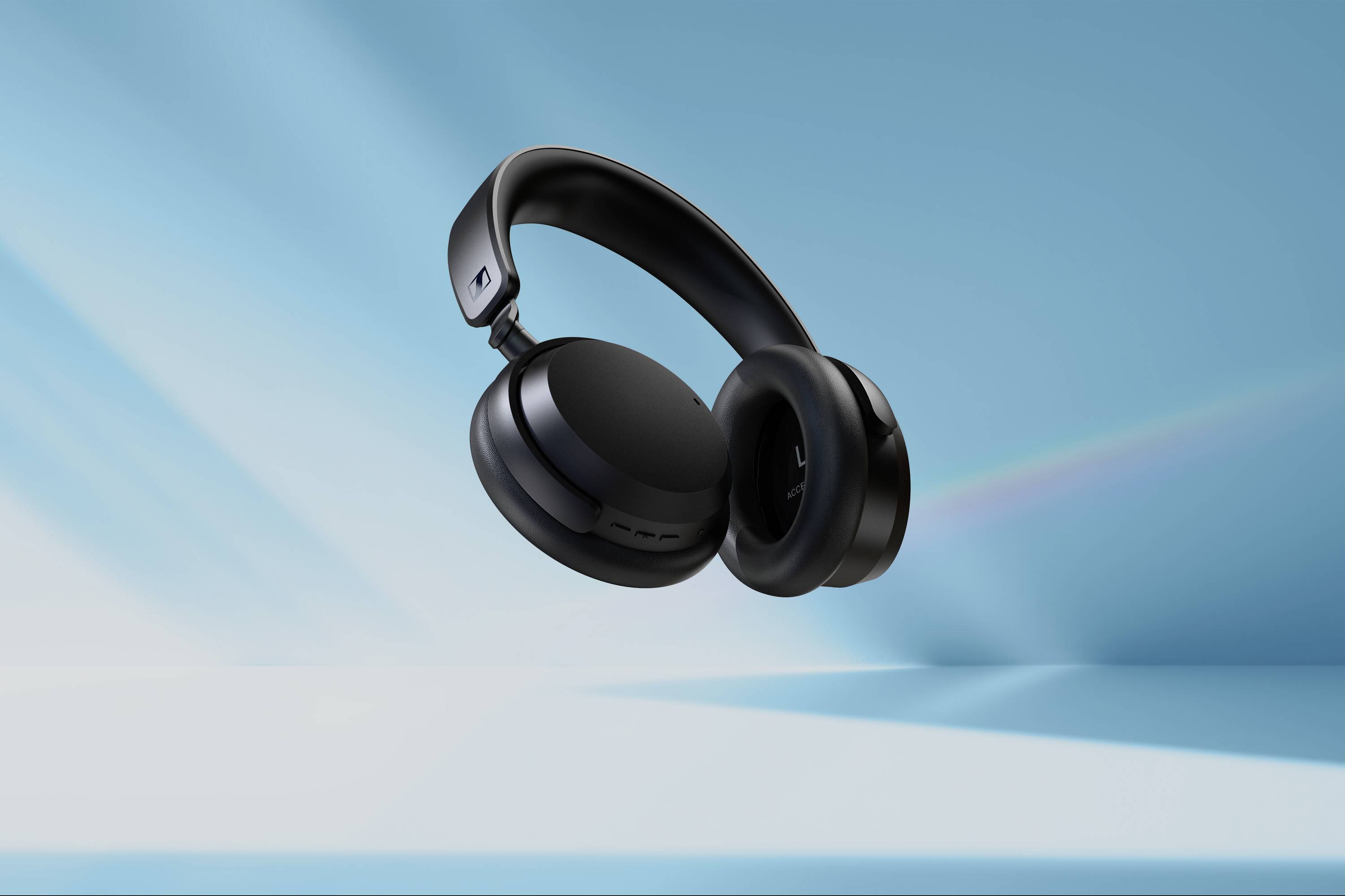 Schwarze, kabellose Kopfhörer schweben vor einem blauen, strahlenden Hintergrund.
