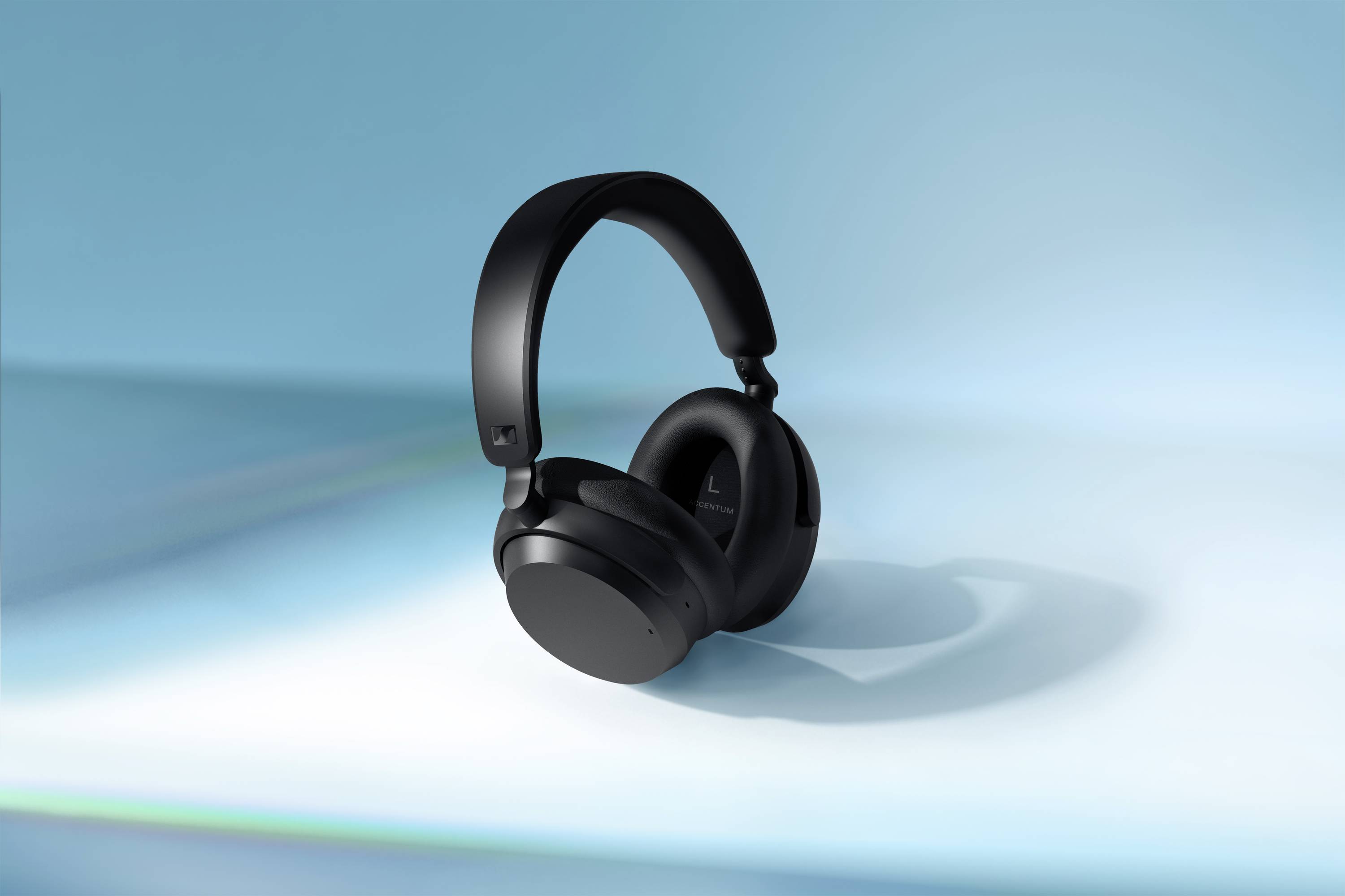 Schwarzer, kabelloser Kopfhörer schwebt vor blauem Hintergrund.