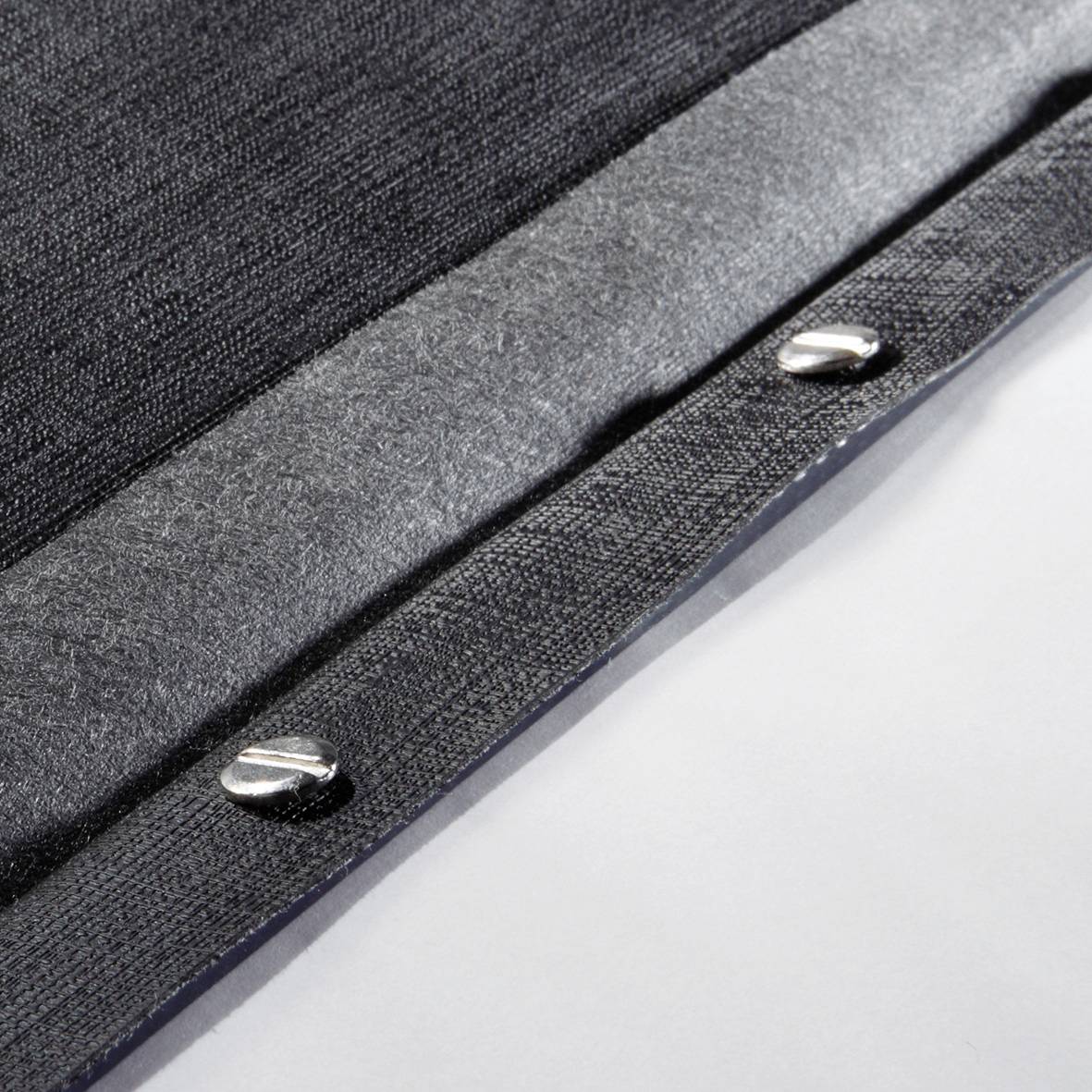 Metallknöpfe auf grauem Stoff; Detailansicht einer Kleidung oder Accessoire.