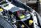 'Ein Auto springt mit einer tragbaren Batterie-Starthilfe an. Kabel sind an die Autobatterie angeschlossen, um den Ladevorgang zu starten.'