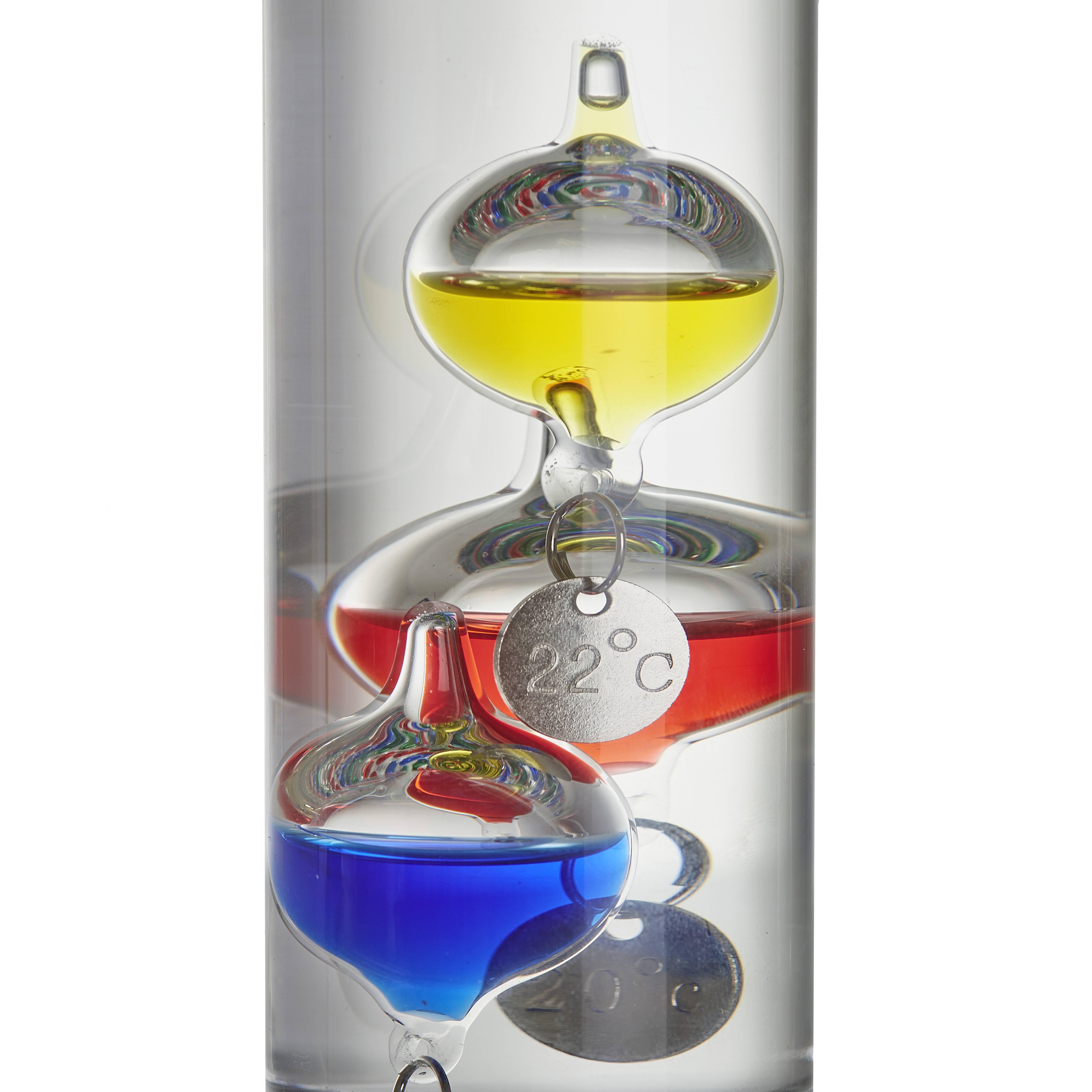 Ein Galileo-Thermometer mit farbigen Kugeln zeigt eine Temperatur von 22 Grad Celsius an. Die Kugeln sind gelb, rot und blau.