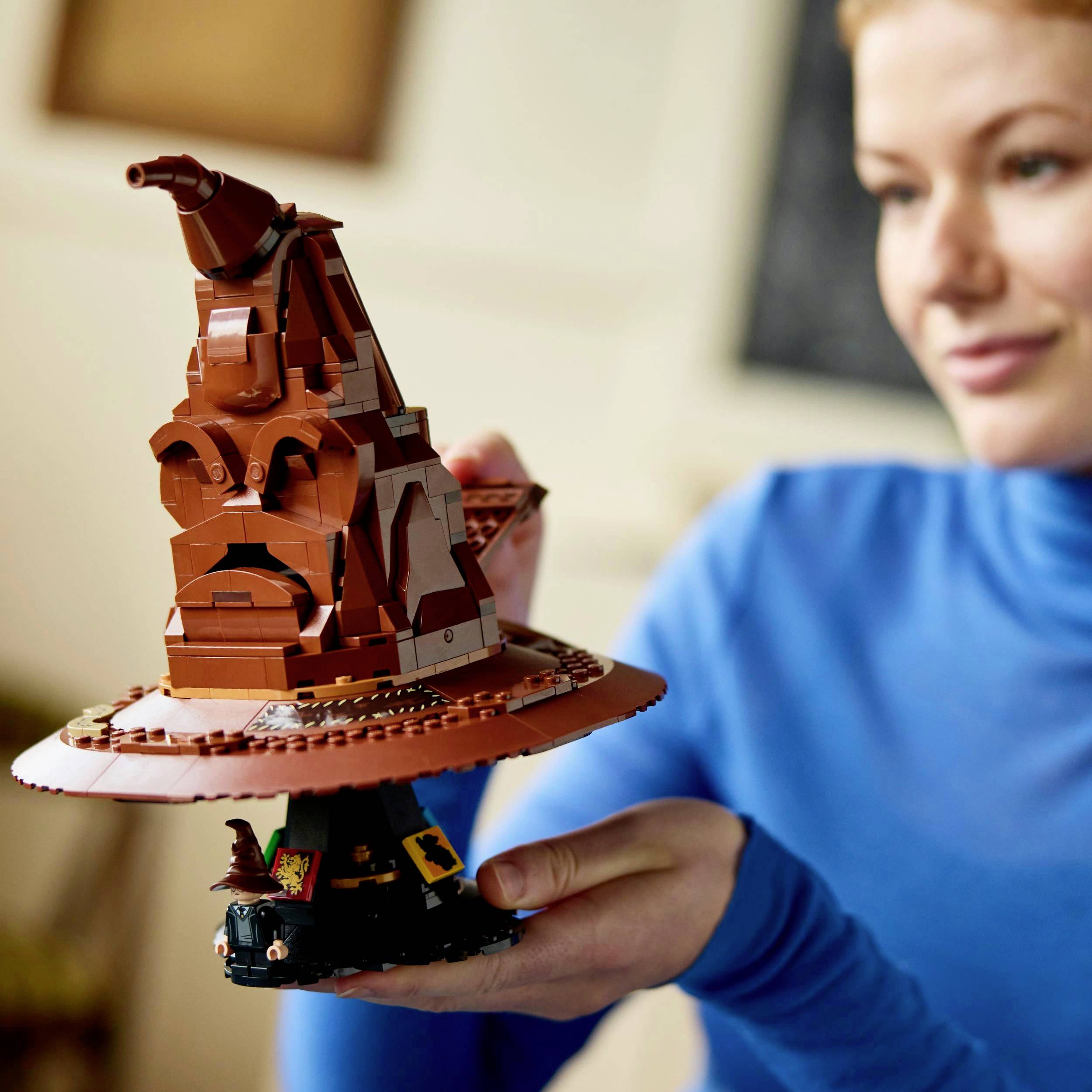 Eine Person hält ein Modell des sprechenden Huts aus LEGO in der Hand. Der Hut ist detailreich gestaltet und steht im Vordergrund.