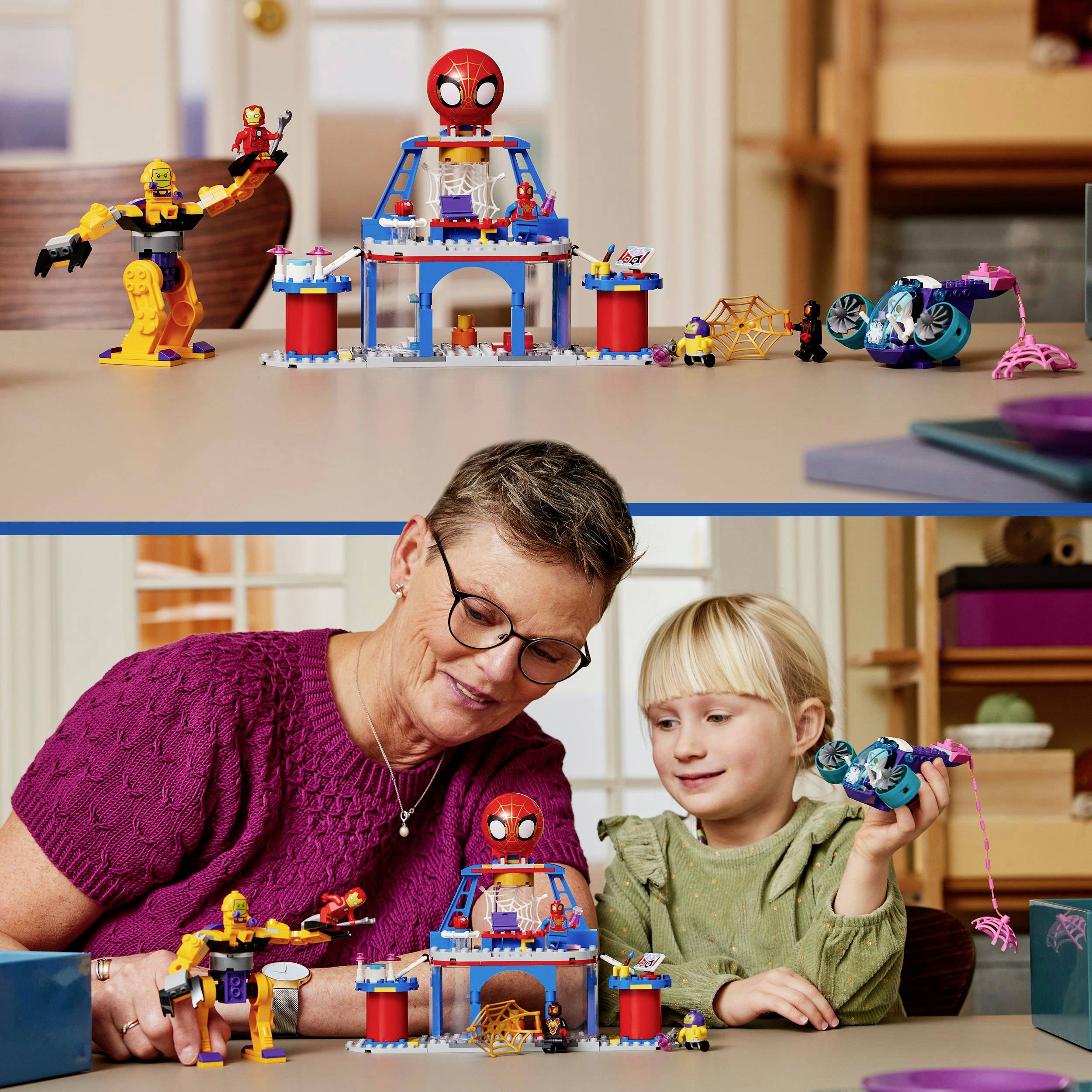 Eine erwachsene Person und ein Kind spielen gemeinsam mit einer bunten LEGO-Spielfigur, die eine Superhelden-Themenwelt darstellt.